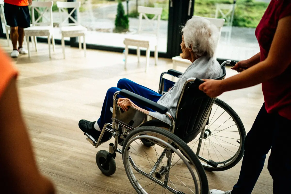 Franchise owner conducting a team briefing with care workers in an office setting
