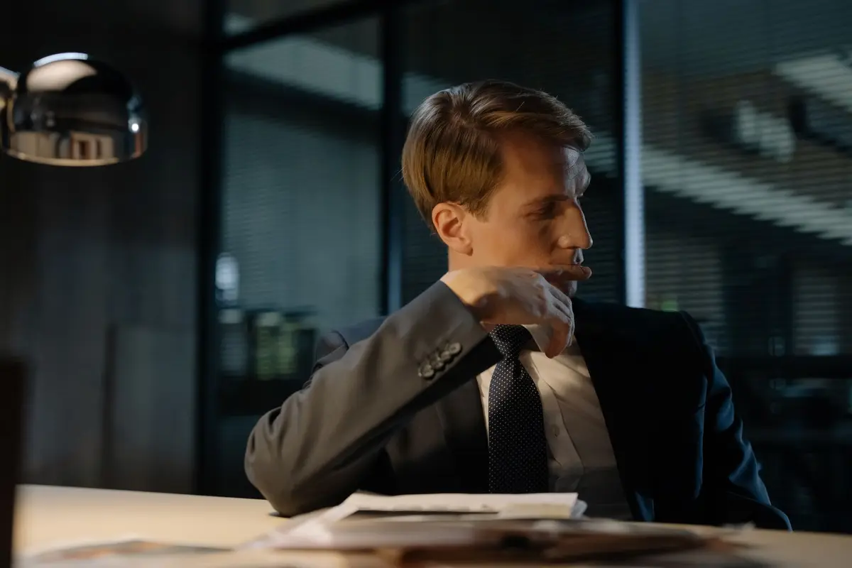 Two people sitting across a table reviewing printed documents during a business meeting