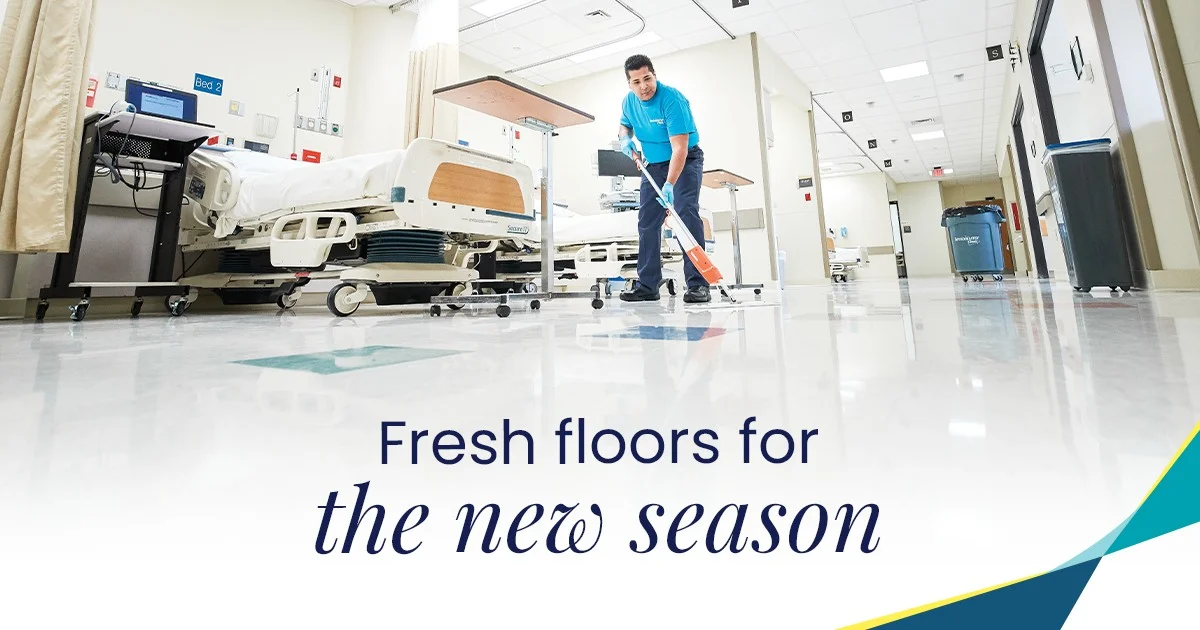 ServiceMaster Clean operative in a teal branded polo using a floor scrubber on a hospital ward floor between patient beds, with a 'Fresh floors for the new season' marketing overlay - example of the network's healthcare cleaning specialism